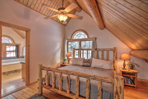 um quarto com uma cama de madeira e uma ventoinha de tecto em Rustic Gotham Bay Cabin on Lake Coeur dAlene em Harrison
