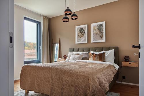 een slaapkamer met een bed en een groot raam bij Designer Apartments in Smíchov by Prague Days in Praag