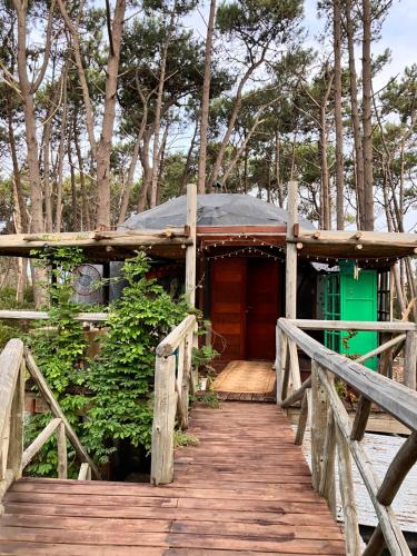 un pont en bois menant à une maison avec une porte verte dans l'établissement DomosdeMar, à Ocean Park