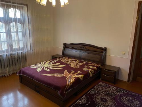 ein Schlafzimmer mit einem Bett mit einer lila Bettdecke in der Unterkunft Family Guest House in Qusar