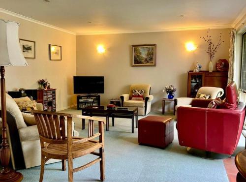 uma sala de estar cheia de mobiliário e uma televisão de ecrã plano em Family Holiday Home em Inverloch