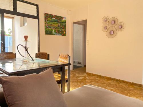 a living room with a table and a couch at Grand appartement composé de 2 terrasses avec vue sur mer in Les Trois-Îlets