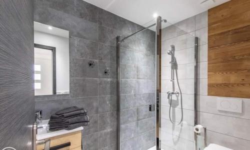 a bathroom with a shower with a glass door at STUDIO LA TOURNETTE in Montmin