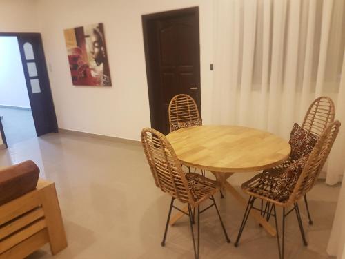 a wooden table and chairs in a room at Le Montebello in Cotonou