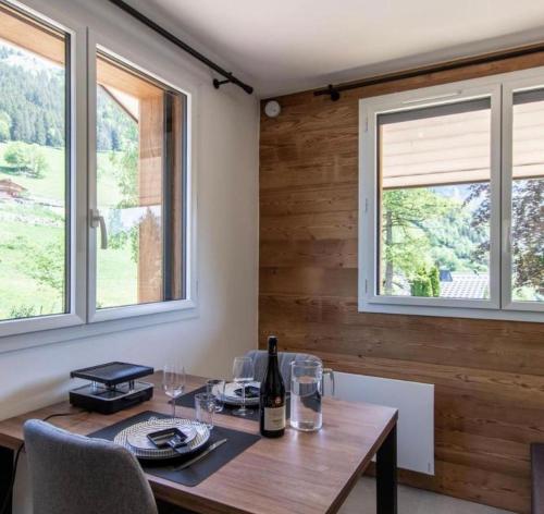 Montmin的住宿－STUDIO LA TOURNETTE，一间带桌子和2个窗户的用餐室