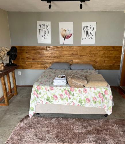 uma cama num quarto com três fotografias na parede em Kitnet 1 - Apart-Hotel Premium em Sete Lagoas