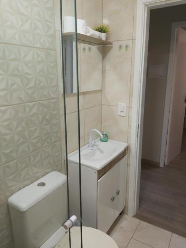a small bathroom with a toilet and a sink at Casa de Temporada Gramado in Gramado