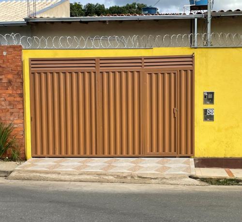una puerta de garaje marrón en un edificio amarillo en Kitnet 1 - Apart-Hotel Premium, en Sete Lagoas