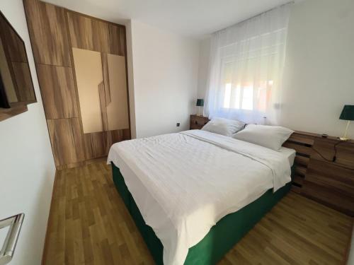 a bedroom with a large bed with white sheets at Hany Sweet in Niš