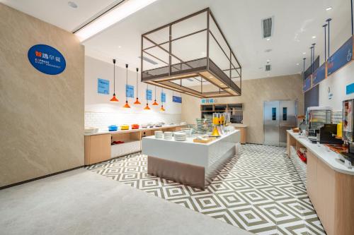 a large kitchen with a counter in a restaurant at Holiday Inn Express Chengdu Tianfu Square by IHG - Chunxi Road and Kuanzhai Alley in Chengdu