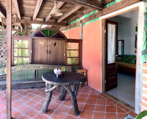 Habitación con mesa y habitación con puerta en Amarelo Hibisco, en Guarda do Embaú