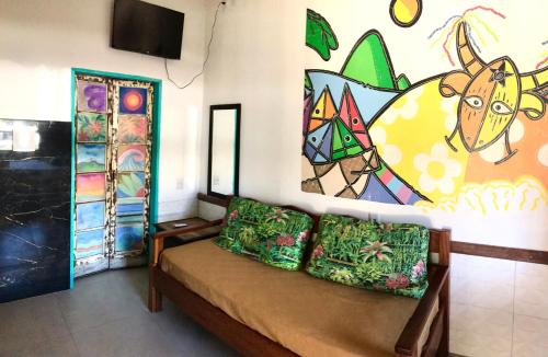 una habitación con sofá y una pintura en la pared en Amarelo Hibisco, en Guarda do Embaú