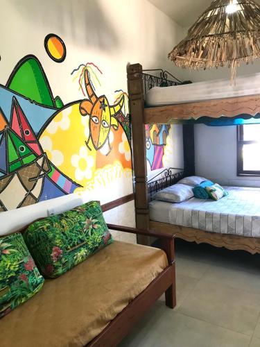 a room with two bunk beds with a mural at Amarelo Hibisco in Guarda do Embaú