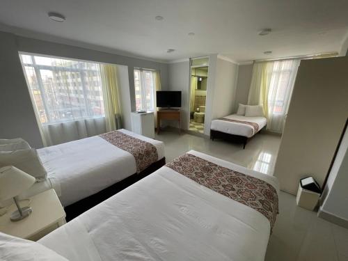 a hotel room with two beds and a television at Hotel Premier in Tacna