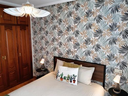 a bedroom with a bed with a patterned wall at LA ERIA II, muy luminoso,WIFI, garaje,15 a pie al centro in Oviedo