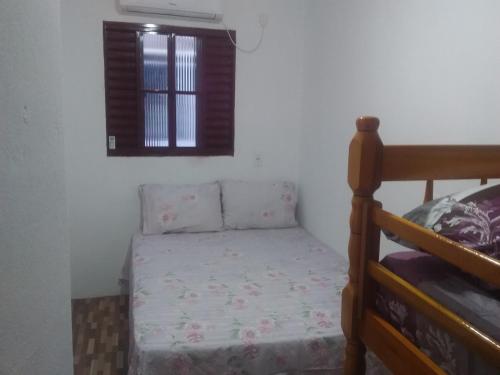 um pequeno quarto com uma cama e uma janela em Pousada Recanto do Coruja em São Gabriel