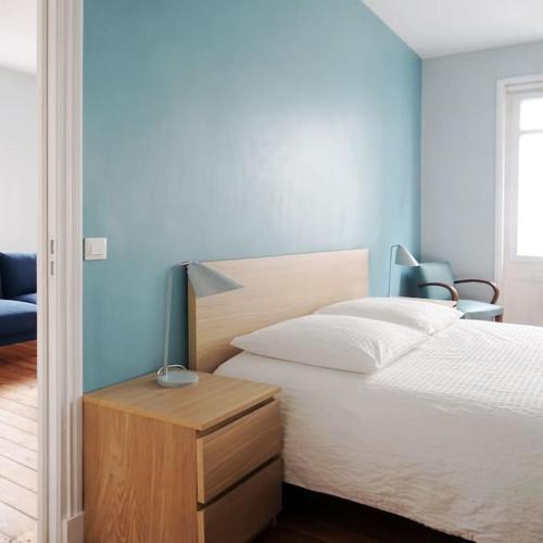 - une chambre avec un lit, un bureau et une lampe dans l'établissement Au cœur de Trouville. Appartement de 3 pièces., à Trouville-sur-Mer