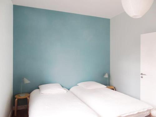 - 2 lits jumeaux dans une chambre aux murs bleus dans l'établissement Au cœur de Trouville. Appartement de 3 pièces., à Trouville-sur-Mer