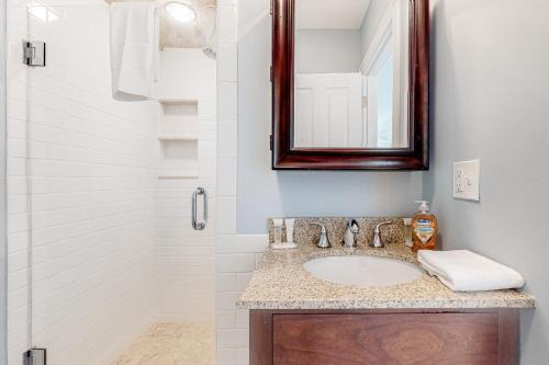 a bathroom with a sink and a mirror and a shower at Sunset View in Wells