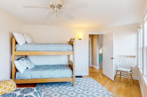 a room with two bunk beds and a chair at Sunset View in Wells