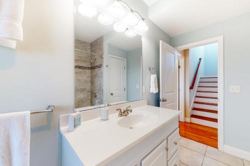 a white bathroom with a sink and a mirror at Bayberry Beauty in Nameloc Heights