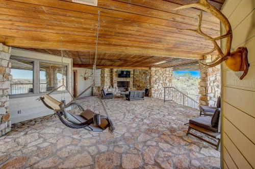 a living room with a stone fireplace and a rocking chair at Stone Lodge in Spicewood