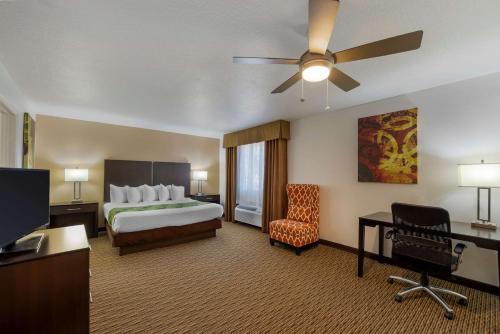 Habitación de hotel con cama y ventilador de techo. en Best Western Mesquite Inn, en Mesquite