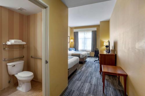 a hotel room with two beds and a toilet at Best Western PLUS University Park Inn & Suites in State College