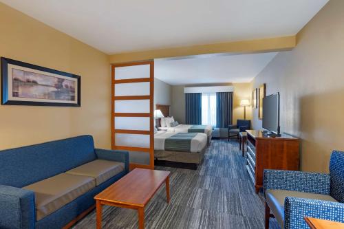 um quarto de hotel com uma cama e uma sala de estar em Best Western PLUS University Park Inn & Suites em State College