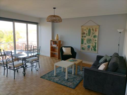 un salon avec un canapé, une table et des chaises dans l'établissement Appartement lumineux et spacieux en centre ville, à Dieppe