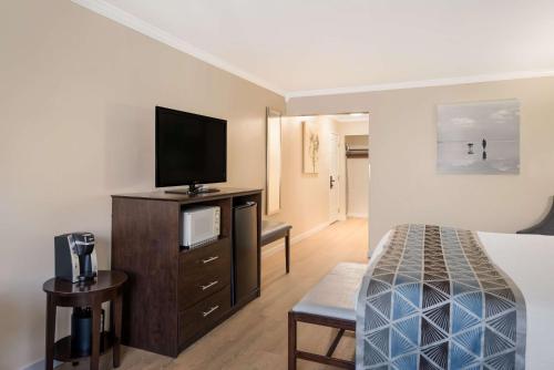a hotel room with a bed and a flat screen tv at Best Western Mountain View Inn in Springville