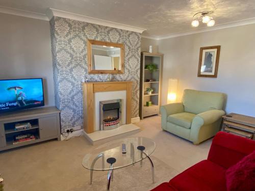 sala de estar con chimenea y TV en City Centre Convenient Contractor Stay With Free Parking and Free Wifi en Bedford