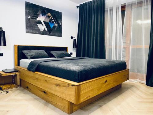Un dormitorio con una cama de madera en una habitación. en Apartment La Tonalina, en Passo del Tonale