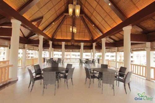 a dining area with tables and chairs in a building at Cozy 2BR with FREE Pool beside SM City Mall in Davao City
