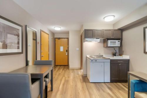 a kitchen with a table and a dining room at Best Western Premier Aberdeen Kamloops in Kamloops