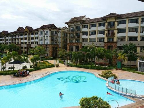 a large swimming pool in front of a large apartment building at Cozy 2BR with FREE Pool beside SM City Mall in Davao City