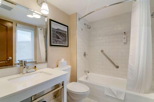 a bathroom with a sink and a toilet and a tub at Best Western Premier Aberdeen Kamloops in Kamloops