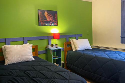 a room with two beds and a green wall at Summertime III in Bar Harbor