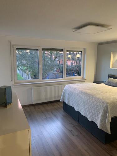 een slaapkamer met een groot bed en 2 ramen bij Ferienwohnung Vanessa in Remagen