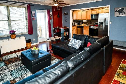 a living room with a leather couch and a kitchen at Modern Designed DTWN Condo with a 99 percent Walk Score in Atlanta