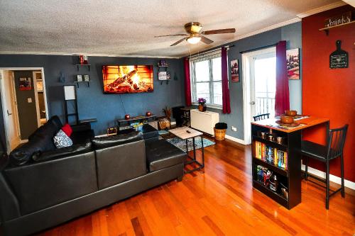 a living room with a couch and a tv on the wall at Modern Designed DTWN Condo with a 99 percent Walk Score in Atlanta
