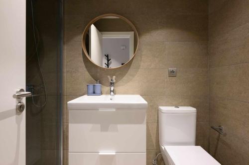 a bathroom with a sink and a toilet and a mirror at Canteras Urban Beach in Las Palmas de Gran Canaria