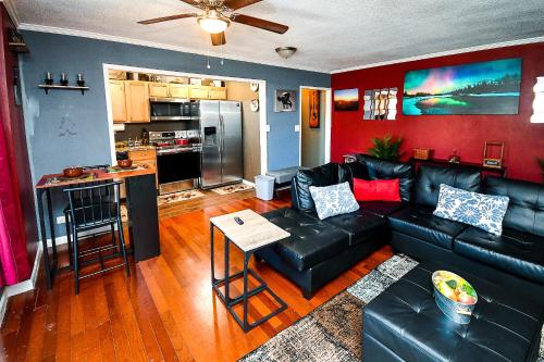 a living room with a black leather couch and a kitchen at Modern Designed DTWN Condo with a 99 percent Walk Score in Atlanta