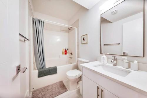 a white bathroom with a sink and a toilet at The Nook & Cranny Bsmt Suite, Near WEM & DT, Fast WiFi! Sleeps 4 in Edmonton