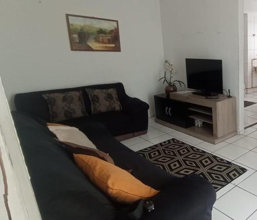 sala de estar con sofá y TV en Apto Mod life, en Campos dos Goytacazes
