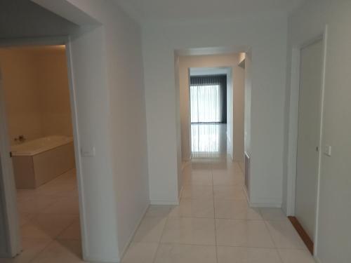 an empty hallway with white walls and a window at Luxurious entire family home in Mooroopna