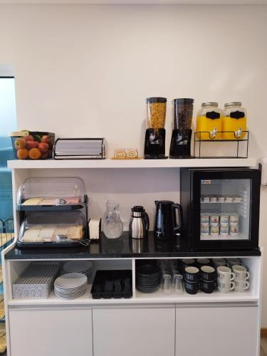 een plank met een koffiezetapparaat en een magnetron bij Santa Alegria Hostel in Ponta Delgada