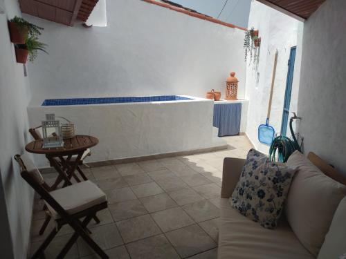 ein Wohnzimmer mit einem Sofa, einem Tisch und einer Badewanne in der Unterkunft Pias Baixinho in Pias