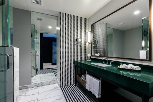a bathroom with a green sink and a mirror at Hotel Indigo - Los Angeles Downtown, an IHG Hotel in Los Angeles