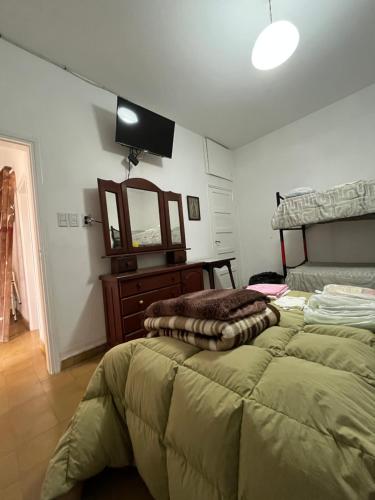 a bedroom with a bed and a dresser and a mirror at Casa de Tati en Cosquín Córdoba in Cosquín